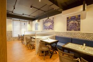 a restaurant with a bar with tables and chairs at MGM Vailankanni in Velankanni