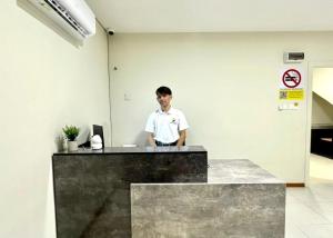 a man standing behind a counter in a room at Swing & Pillows - Salak Tinggi , KLIA 1 KLIA 2 in Sepang +18 photos