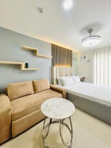 a bedroom with a bed and a couch and a table at Bernwood Tower in Iloilo City
