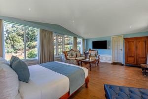 ein Schlafzimmer mit einem großen Bett und einem Fernseher in der Unterkunft Tiverton Bungalow in Udagamandalam