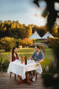 a man and woman sitting at a table at Glamping Bizjak in Preddvor