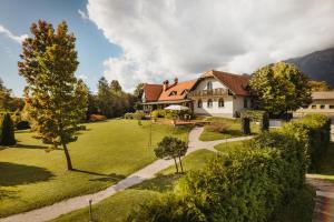 a large white house with a grass yard at Glamping Bizjak in Preddvor