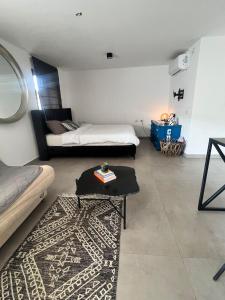 a living room with a bed and a rug at הסטודיו in Beer Sheva