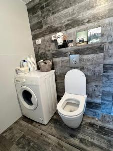 a bathroom with a toilet and a washing machine at הסטודיו in Beer Sheva