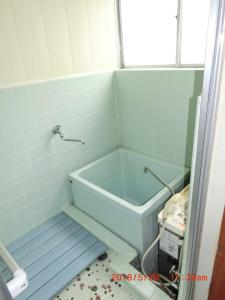 ein Bad mit einer blauen Badewanne in einem Zimmer in der Unterkunft YabFarm Lodge 202 in Kashiwa