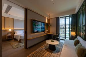 een hotelkamer met een bed en een tv bij Holiday Inn Pu'er Jingmai by IHG in Mengman