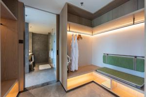 een kamer met een spiegel en een kleedkamer bij Holiday Inn Pu'er Jingmai by IHG in Mengman