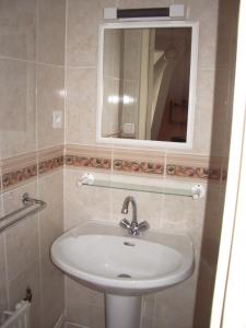 La salle de bains est pourvue d'un lavabo et d'un miroir. dans l'établissement Les Glycines, à Plaimpied-Givaudins