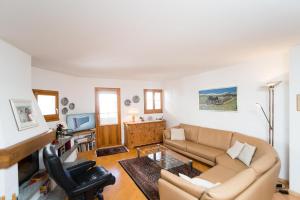 a living room with a couch and a tv at Chesa Aquileja Trüb in Pontresina