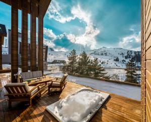 eine Terrasse mit Tisch und Stühlen auf einem Deck in der Unterkunft Kaya Palazzo Ski & Mountain Resort in Kartalkaya