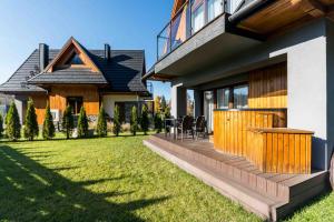 een huis met een achtertuin met een houten terras bij Prywatna Sauna i jacuzzi! Tatra Spa Witów in Witów