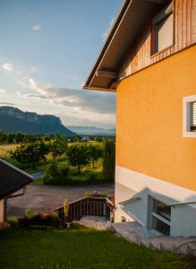 a building with a balcony and a view of a yard at Die Naradhube Ferienwohnungen Wolte in Abriach