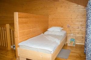 a wooden room with a bed in the corner at Die Naradhube Ferienwohnungen Wolte in Abriach