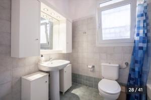 une salle de bain blanche avec toilettes et lavabo dans l'établissement Haris Papa Villa Kallithea Halkidiki 2, à Afytos