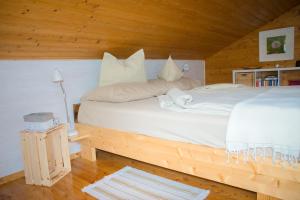 a bedroom with a bed with white sheets and pillows at Die Naradhube Ferienwohnungen Wolte in Abriach