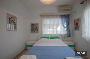 - une chambre avec un lit bleu et blanc et une fenêtre dans l'établissement Haris Papa Villa Kallithea Halkidiki 2, à Afytos