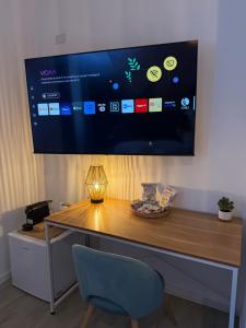 un bureau avec une télévision accrochée au mur dans l'établissement Fly Inn Fiumicino Guest House, à Fiumicino