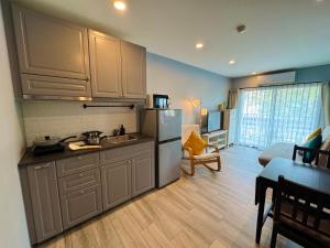 a kitchen with a sink and a refrigerator in a room at Comfy studio - 10 min walk to NaiYang Beach in Nai Yang Beach