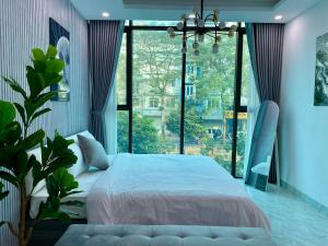 a bedroom with a large bed and a large window at Grand C Homestay in Hanoi