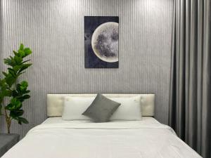 a bedroom with a white bed with a picture of the moon at Grand C Homestay in Hanoi