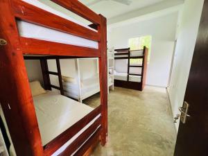 a room with two bunk beds and a door at Kuchu surf hostel in Weligama +6 photos