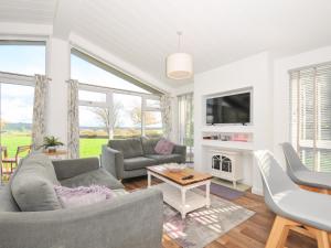 リスカードにある9 Horizon Viewのソファ2つとテレビのあるリビングルーム