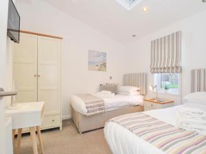 リスカードにある9 Horizon Viewのベッド2台、机、テレビのある寝室