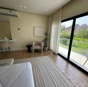 a living room with a couch and a large window at Hatta Valley Lodge in Hatta