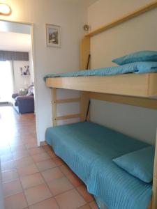 グリモーにあるappartement avec vue sur bateauのベッドルーム1室(二段ベッド2組付)、廊下が備わります。