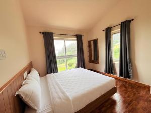 Un dormitorio con una cama y una ventana grande en Bloom Hill Ooty, en Ooty