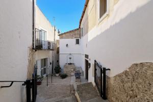 een steegje in een oude stad met witte gebouwen bij Cantine Cippone Room in Monte SantʼAngelo