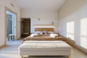 two beds in a white room with two beds sidx sidx sidx at Cantine Cippone Room in Monte SantʼAngelo