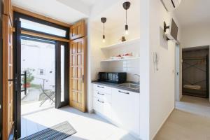 een keuken met witte kasten en een glazen schuifdeur bij Cantine Cippone Room in Monte SantʼAngelo +16 foto's