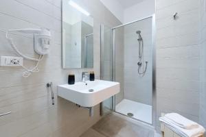 een witte badkamer met een wastafel en een douche bij Cantine Cippone Room in Monte SantʼAngelo