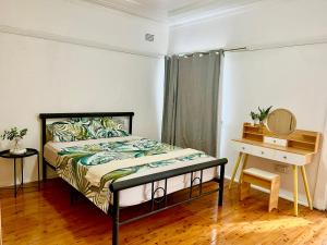 - une chambre avec un lit et une table avec un miroir dans l'établissement A Cosy Private Corner in the City, à Sydney