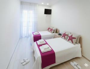 a room with three beds and a tv in it at La Terrazza di Andrea in Imperia