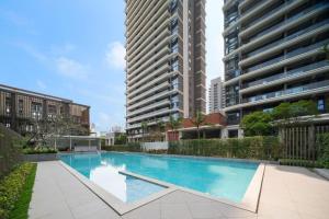 a swimming pool in the middle of two tall buildings at 来咖民宿酒店三亚市中心大悦城店 in Sanya