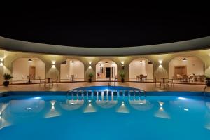 a large pool in a building with tables and chairs at Serene Kabini Wild lodge in Kabini River +96 photos