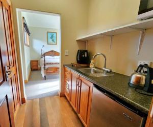 a kitchen with a sink and a kitchen with a bed at Whispering Pines in Kaihinu