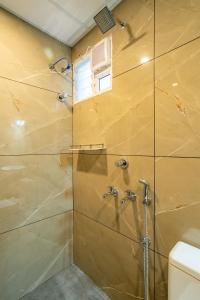 a bathroom with a shower with a glass door at Daan Luxe Inn in Trivandrum