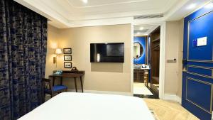 ein Hotelzimmer mit einem Bett und einem Fernseher in der Unterkunft Ashley NewAir Menteng with Air Purifier in Jakarta