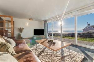 ein Wohnzimmer mit Couch und großem Fenster in der Unterkunft Swn Y Don - Modern Luxury Steps from Newgale Beach Bliss for up to 10 People in Newgale