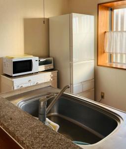a kitchen with a sink and a microwave at Mori no hoshi - Vacation STAY 65135v in Kunigami