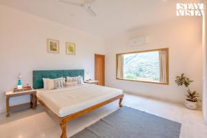 Postel nebo postele na pokoji v ubytování StayVista at Nilaya In The Hills with Lake View, Pool + 25 fotografií