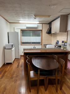 a kitchen with a table and a kitchen with a refrigerator at Mori no hoshi - Vacation STAY 65135v in Kunigami