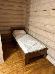 a small wooden room with a bed in a cabin at Котедж ЛАТОРИЦЯ in Laterka