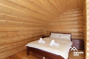 a bedroom with a bed in a wooden room at Котедж ЛАТОРИЦЯ in Laterka
