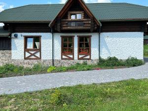 a house with two windows and a stone driveway at Котедж ЛАТОРИЦЯ in Laterka