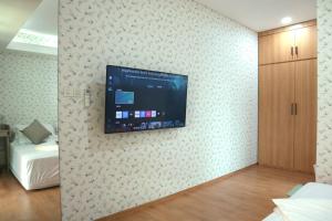Una habitación con un televisor de pantalla plana en una pared. en SS21 Hidden Gem in Jakarta, en Yakarta
