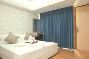 Un dormitorio con una cama blanca con cortinas azules. en SS21 Hidden Gem in Jakarta, en Yakarta